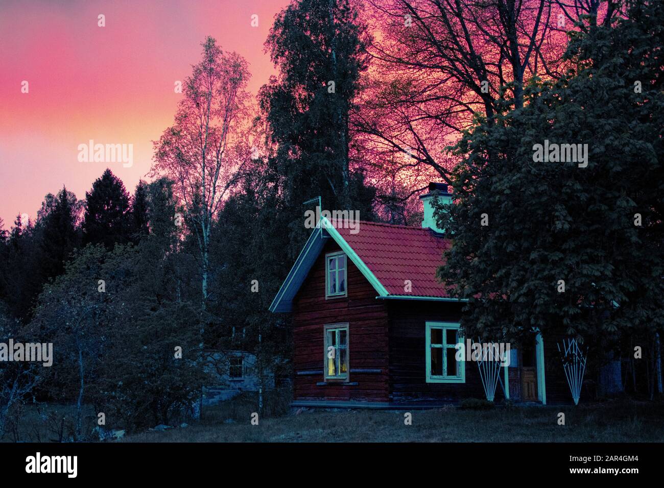 Tradizionale cabina di legno svedese e crepuscolo con cielo rosso drammatico. Foto Stock