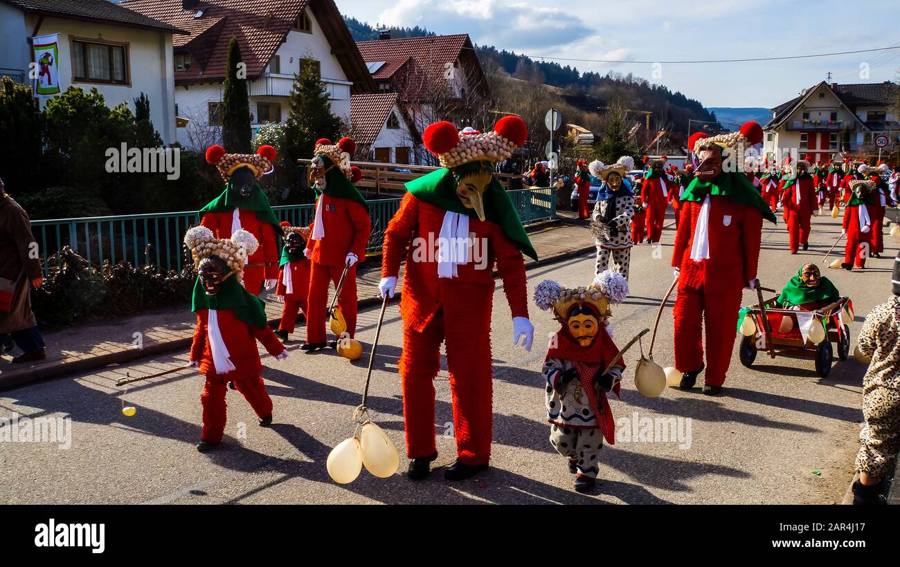 Elzach, Germania, 25 febbraio 2017, tradizionale processione di carnevale di febbraio con molte persone e bambini in costumi rossi e maschere a piedi sulla st Foto Stock