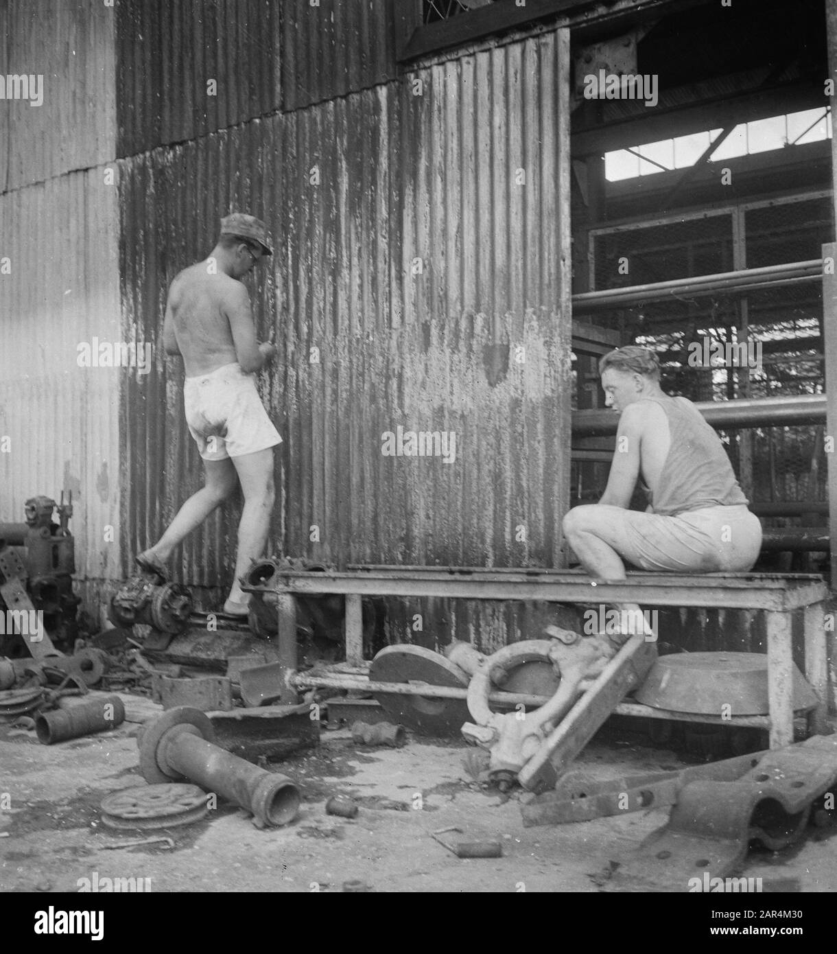 Kloeang-Sekajoe Epill UN plotone di 5-3 RI è stato spostato al VP (polizia di campo) post Kloewang (Sumatra sud). Una fabbrica distrutta consegna i fogli ondulati, che garantirà Arie Zonneveld da Schiedam e Piet Clement Da Va un luogo di riposo secco nel loro nuovo quartiere. Nota: Mirrored .T.a.v. Stampa Data: 6 Marzo 1948 Località: Indonesia, Kluang, Indie Orientali Olandesi, Sekayu, Sumatra Foto Stock