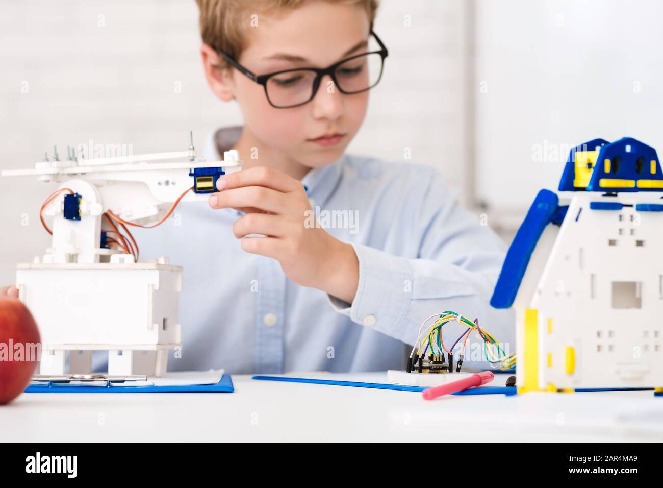 Schoolboy astuto alla lezione di stelo che costruisce robot Foto Stock