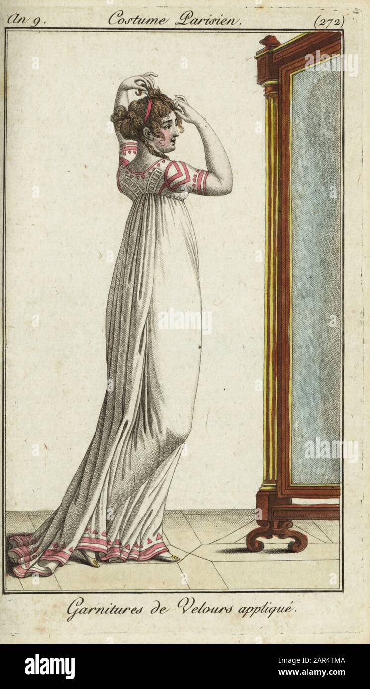 Merveilleuse fissare i capelli con un nastro di fronte a uno specchio, 1800. Il suo abito bianco è decorato con applicazioni in velluto rosa. Garnitures de velours appliqué. Incisione su copperplate colorata a mano di Journal des Modes et Dames di Pierre de la Mesangere, Parigi, 1800. Le illustrazioni del volume 4 erano di Carle Vernet, Bosio, Dutailly e Philibert Louis Debugcourt. Foto Stock
