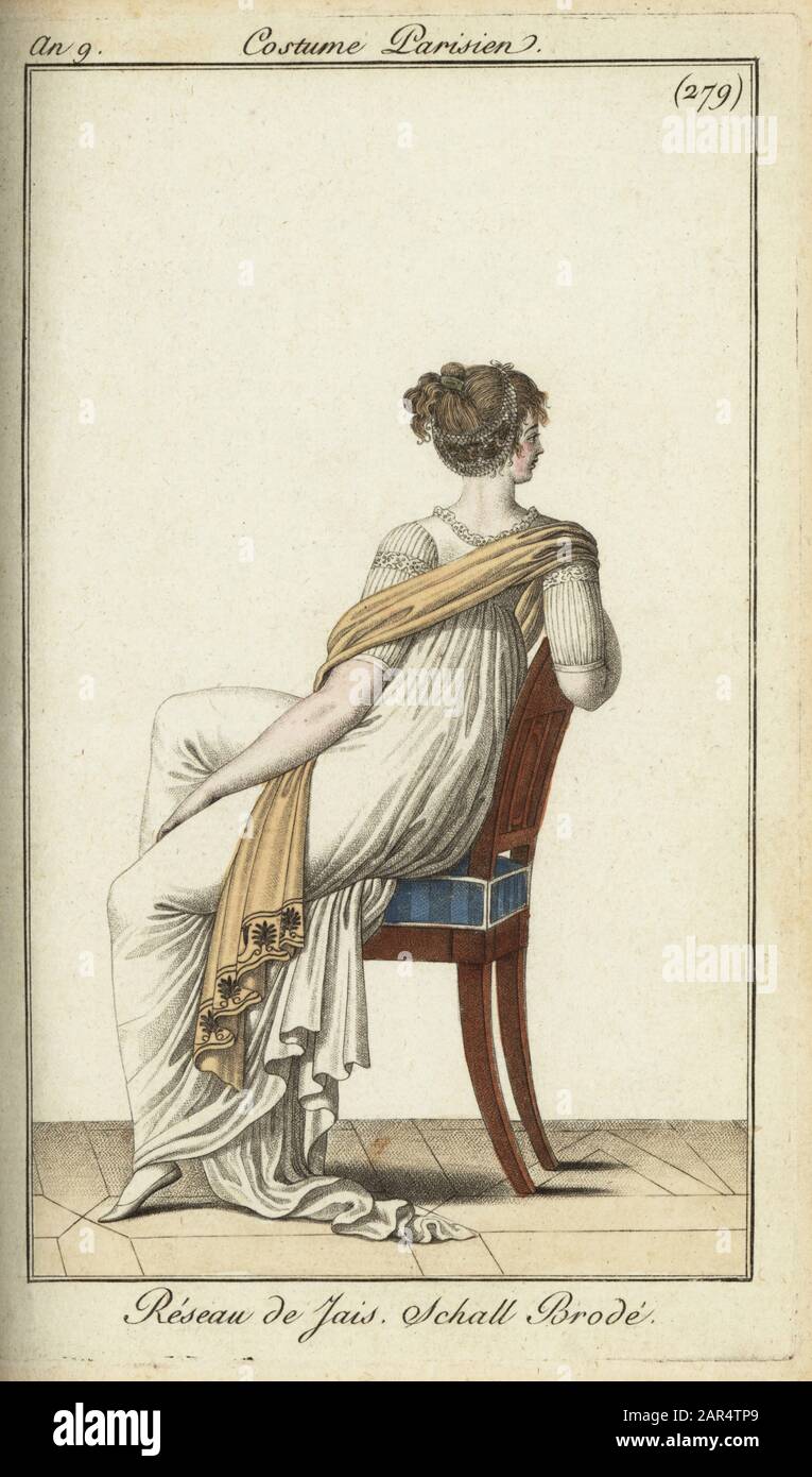Vista posteriore della donna alla moda seduta su uno sgabello, 1801. I suoi capelli sono legati in una rete di jet, e indossa uno scialle ricamato su un semplice abito bianco. Reseau de Jais. Schall Brode. Incisione su copperplate colorata a mano di Journal des Modes et Dames di Pierre de la Mesangere, Parigi, 1801. Le illustrazioni del volume 4 erano di Carle Vernet, Bosio, Dutailly e Philibert Louis Debugcourt. Foto Stock