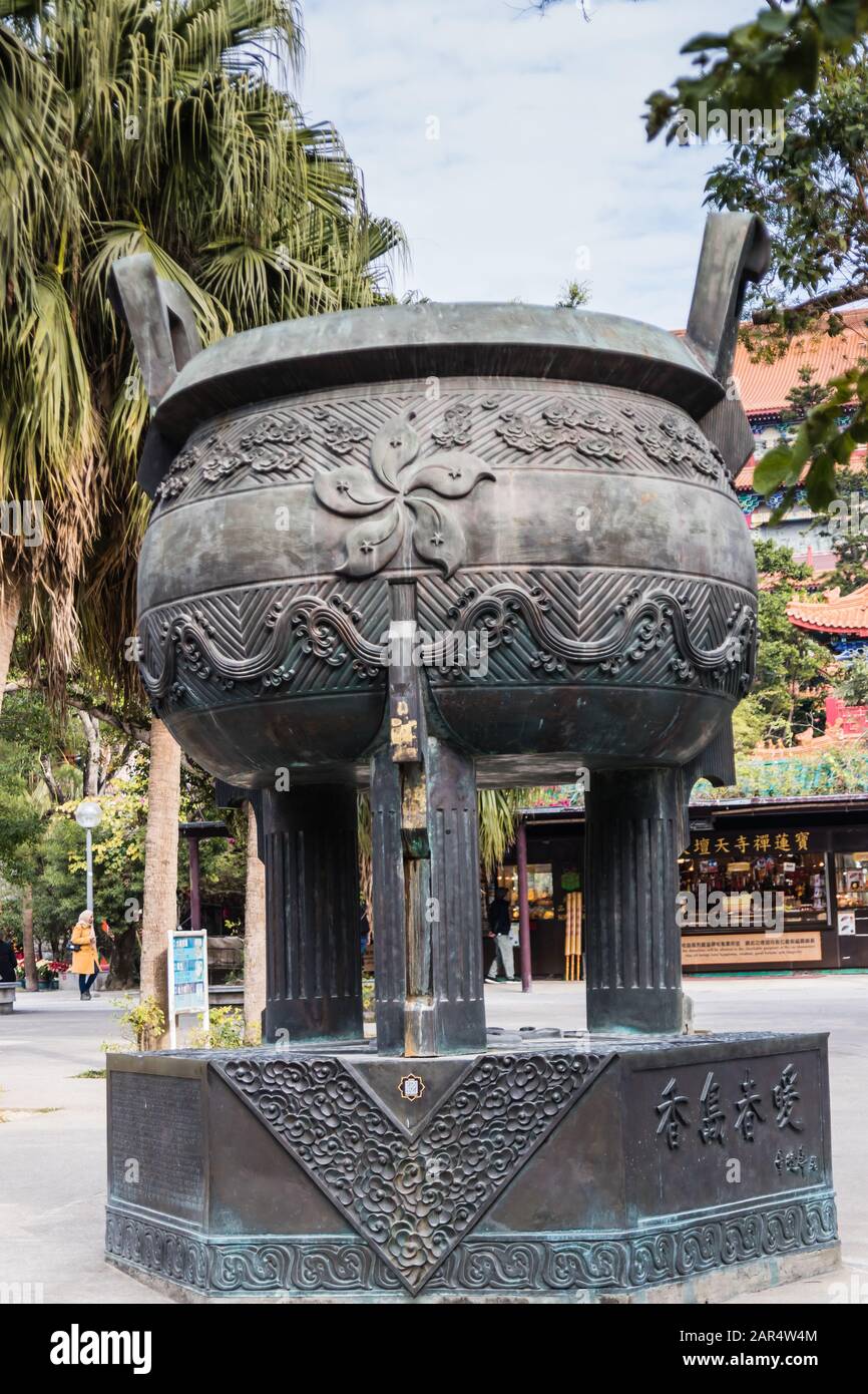 Un gigantesco bruciatore di incenso metallico con un'immagine di fiori di bauhinia vicino all'ingresso del Monastero di po Lin, Isola di Lantau, Hong Kong Foto Stock