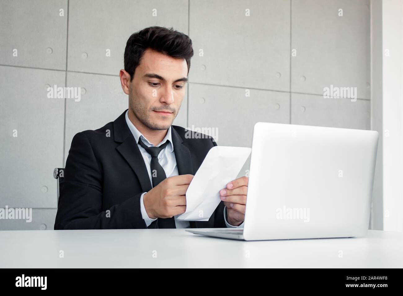 I dipendenti di sesso maschile hanno documenti in scetticismo. Gli uomini d'affari cercano buste sospette che ha ottenuto. Foto Stock