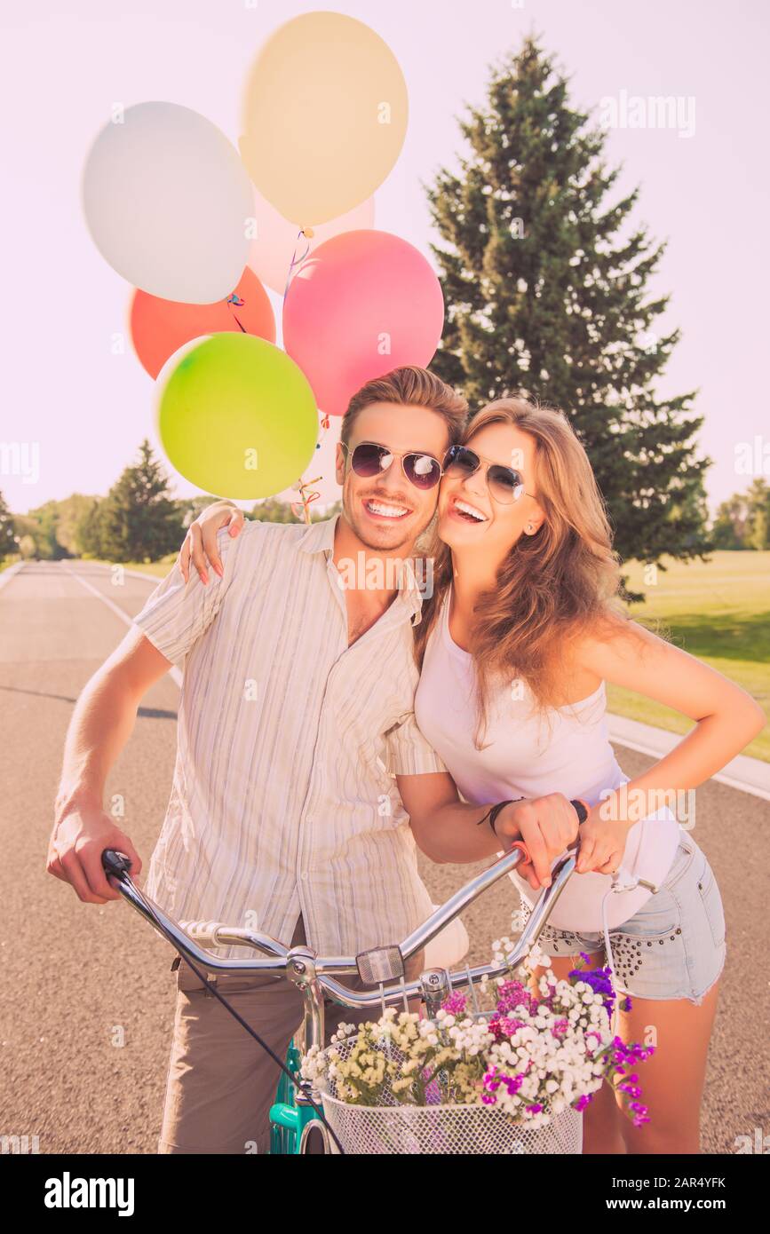 Ritratto di allegra coppia graziosa innamorata di biciclette e palloncini Foto Stock