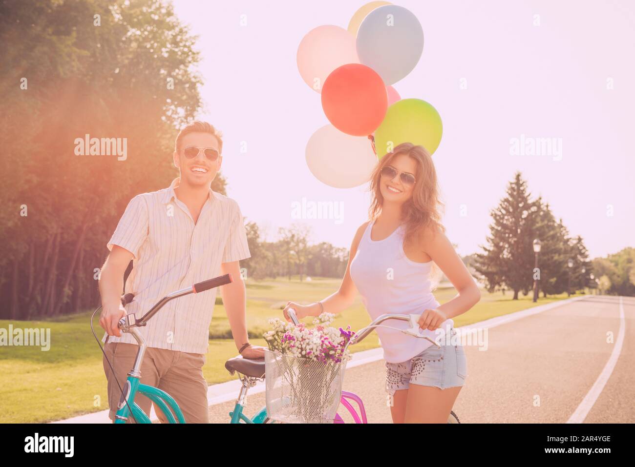Giovane uomo e donna che ha fine settimana con bicicletta e palloncini Foto Stock