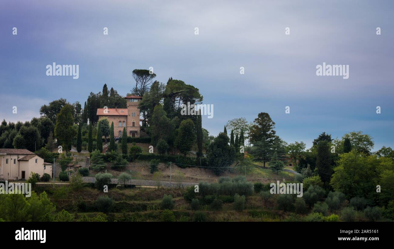 Una piccola città medievale su una collina con molti alberi intorno Foto Stock