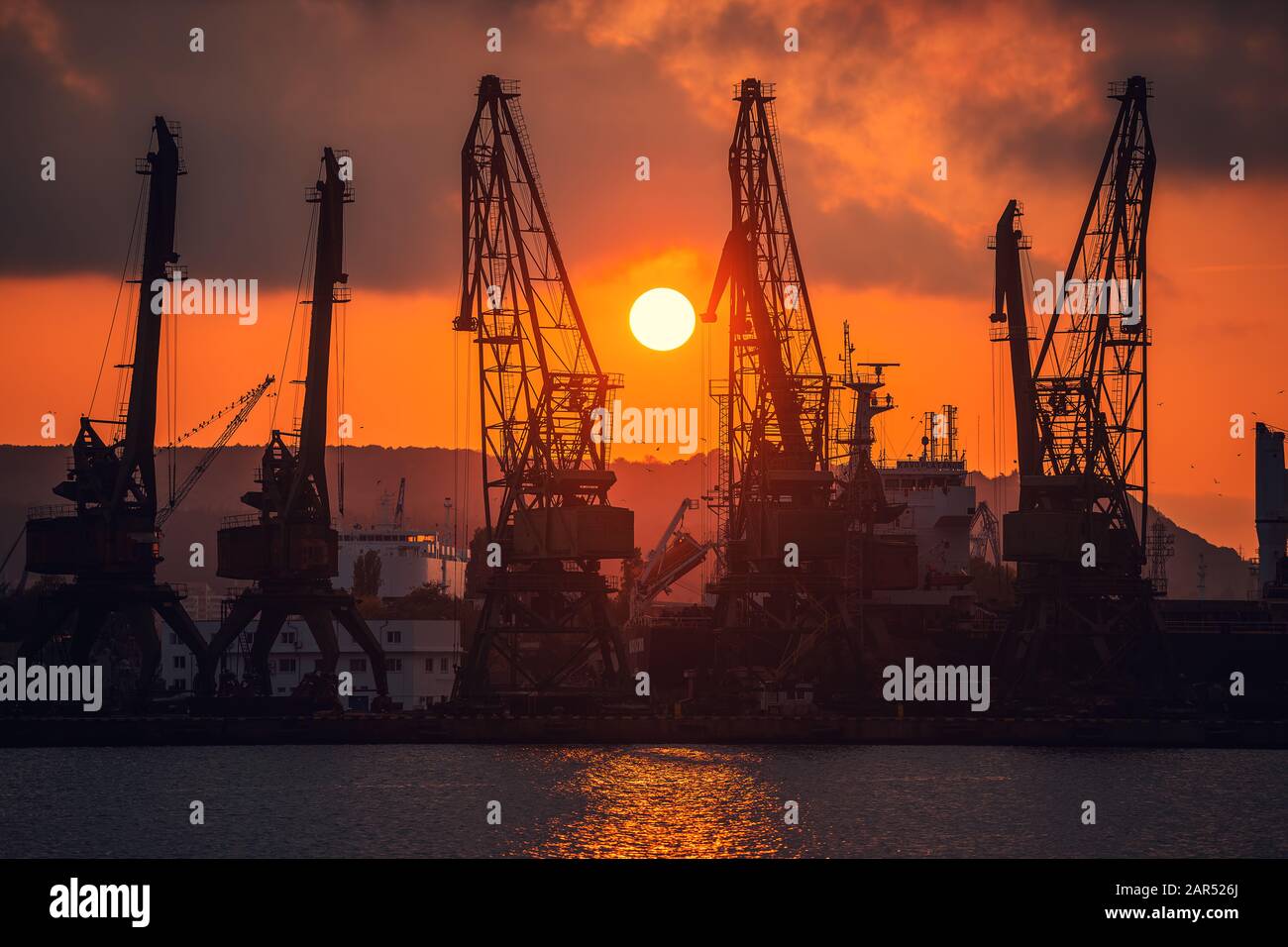 Colorato tramonto sul porto di mare e le gru industriali, Varna, Bulgaria Foto Stock