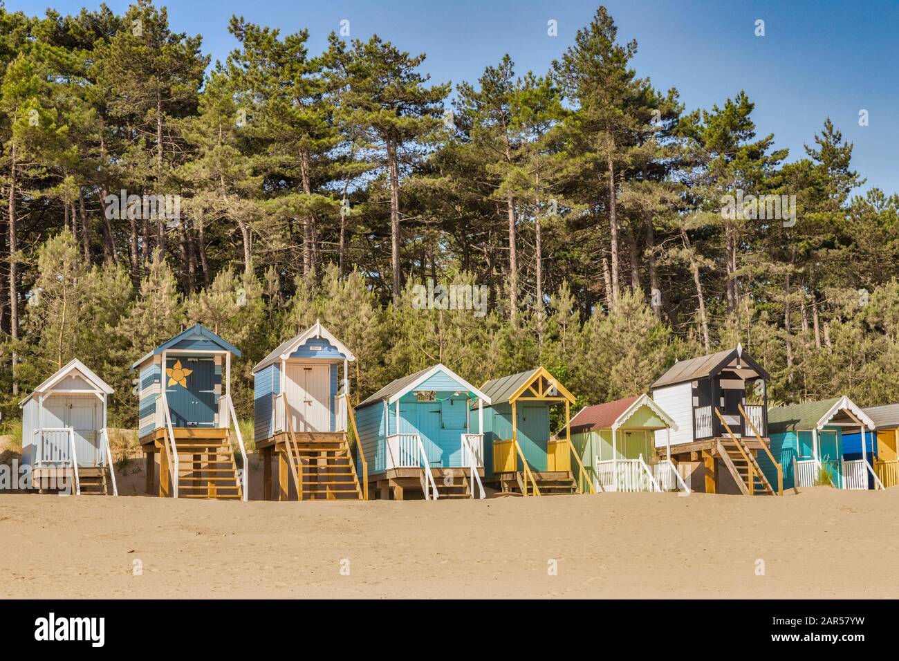 29 giugno 2019: Wells-Next-The-Sea, Norfolk, Inghilterra, Regno Unito - baite sulla spiaggia, pini dietro. Foto Stock