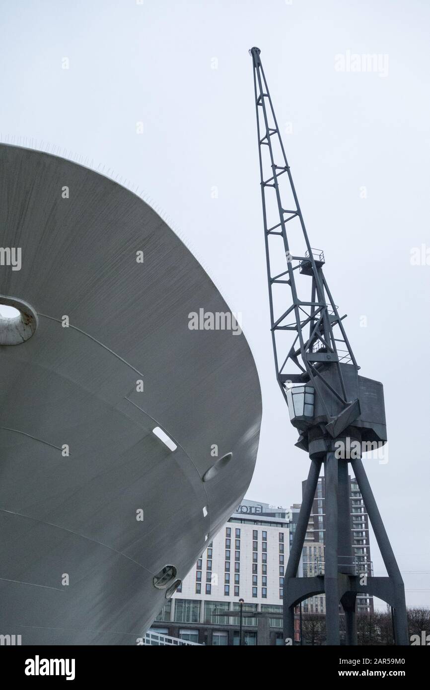 Prua di una nave e vecchia gru industriale a banchina sui Royal Victoria Docks, Londra, Regno Unito Foto Stock