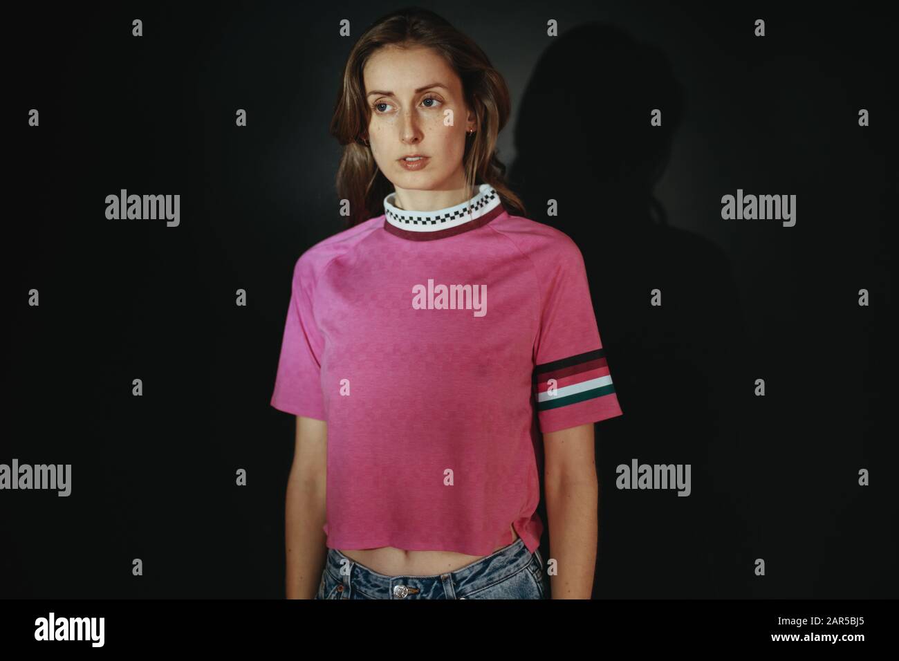 ritratto di bella giovane donna che indossa una camicia rosa Foto Stock
