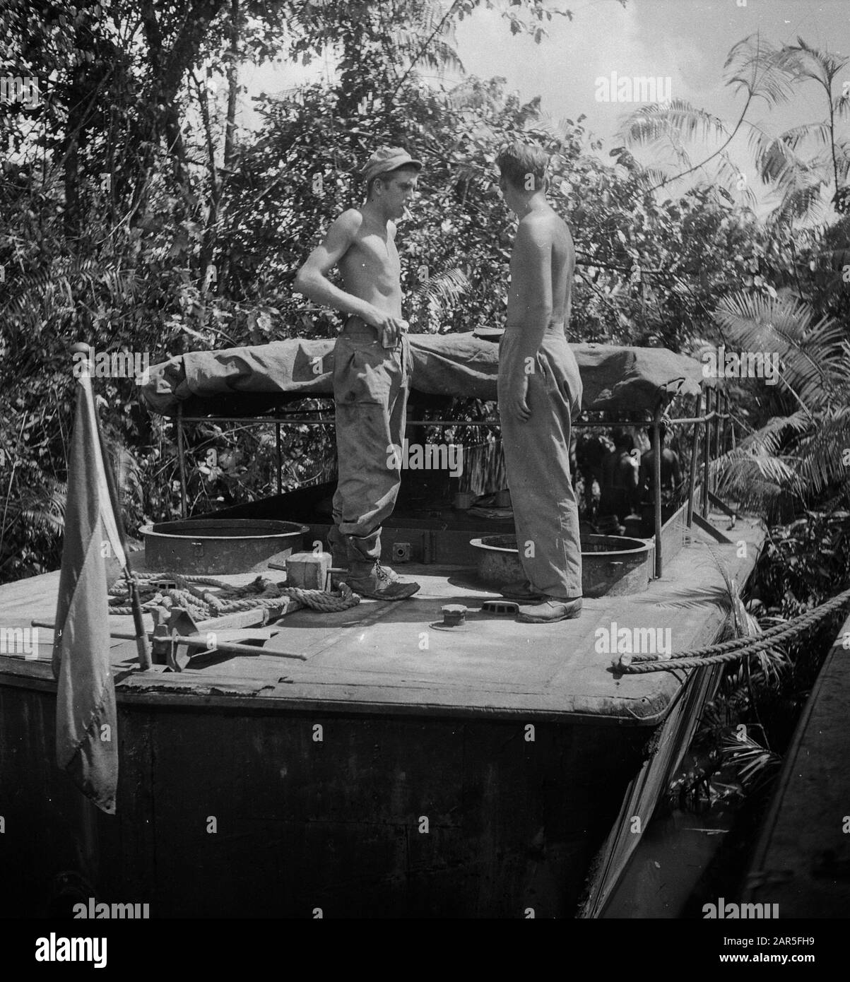 Kloeang-Sekajoe Epil Ipil (Zd.Sumatra): Schipper Hans van de Berg dell'Aia e il suo operatore George Remers di Rotterdam discutono sul ponte della loro LCVP come ottenere al meglio il barang attraverso la fitta vegetazione. Data: 6 Marzo 1948 Località: Indonesia, Kluang, Indie Orientali Olandesi, Sekayu, Sumatra Foto Stock