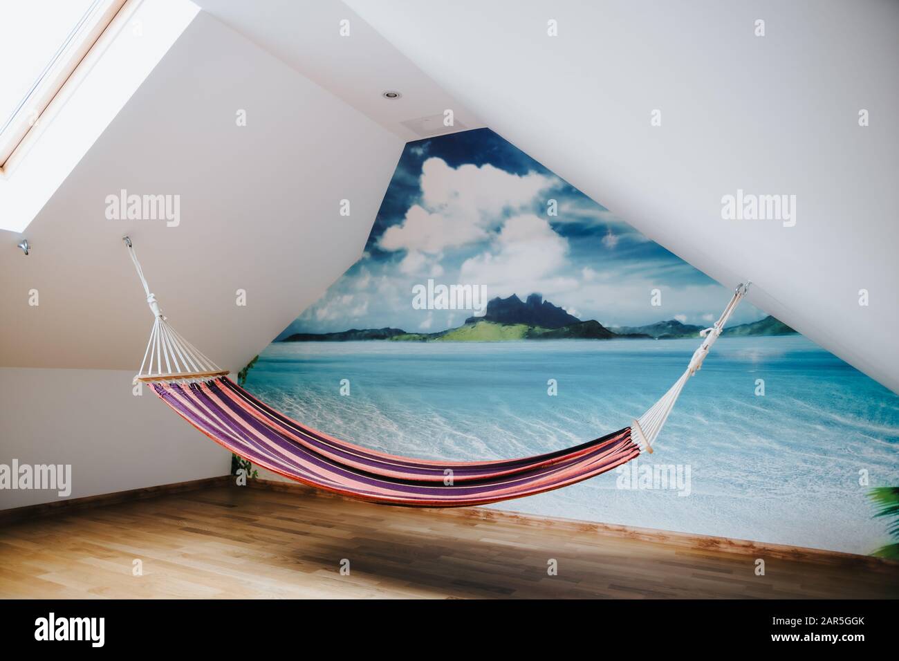 Amaca all'interno di una stanza con una foto panoramica dell'isola  tropicale sul muro Foto stock - Alamy