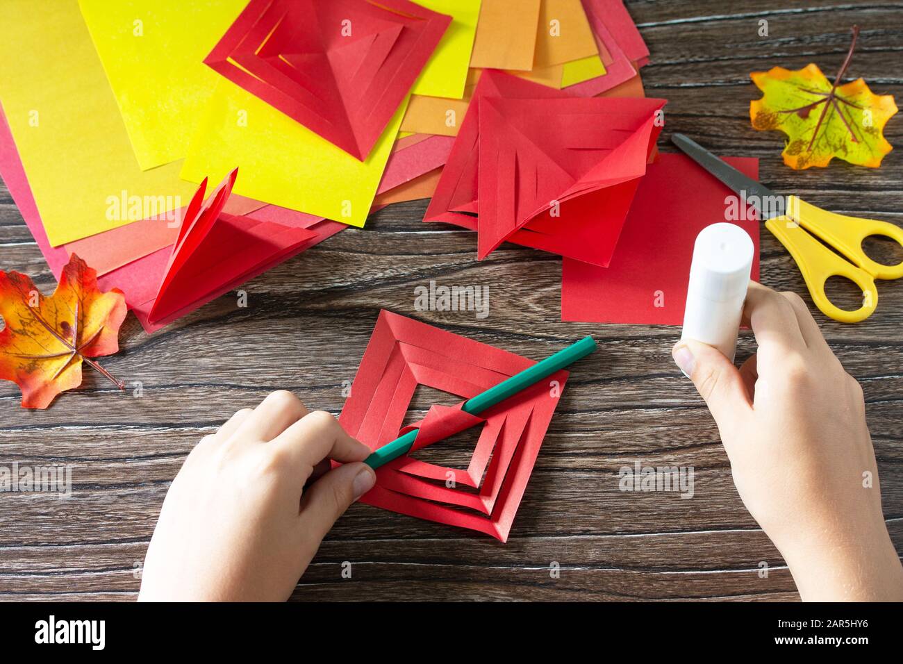 Il bambino raccoglie le foglie di carta. Foglie di carta colorata in  autunno su sfondo di legno. Artigianato dalla carta per bambini. Progetto  d'arte per bambini Foto stock - Alamy