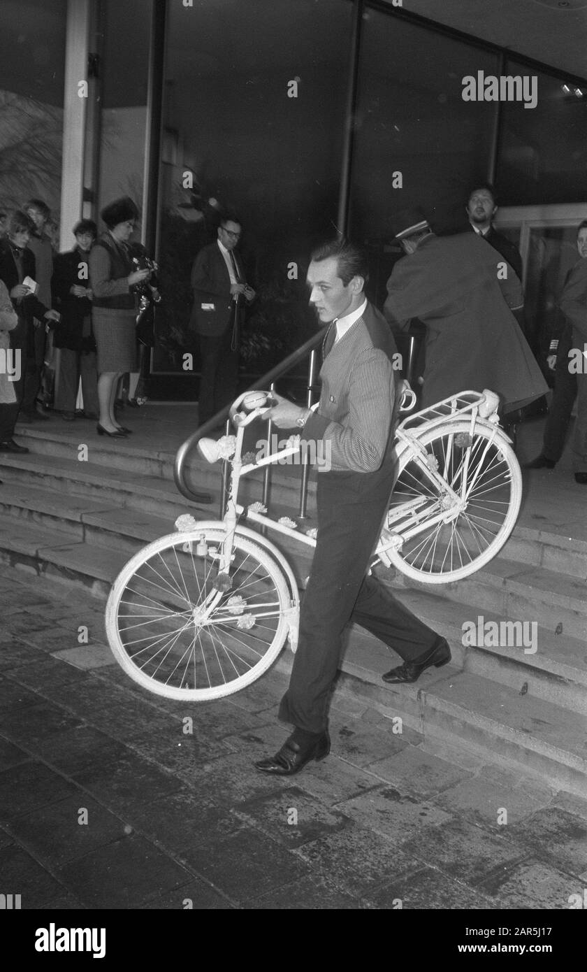 John Lennon e la moglie Yoko Ono lasciano l'Hilton Hotel ad Amsterdam. I Provofiets, che è stato offerto alla coppia, è stato portato a van da personale Data: 31 marzo 1969 posizione: Amsterdam, Noord-Holland Parole Chiave: Biciclette Nome personale: Lennon, John, Ono, Yoko Foto Stock