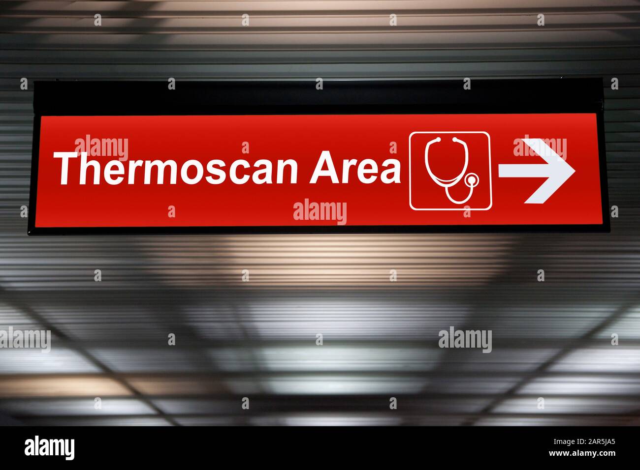 Cartello rosso ThermoScan Area con direzione freccia appeso al soffitto all'aeroporto per controllare la situazione di focolaio ai passeggeri che arrivano al terminal da Publi Foto Stock