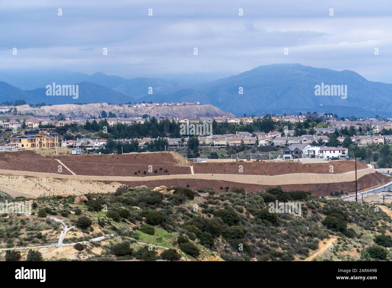 Case in cima alla collina che si affacciano sulla Valle di San Fernando nel quartiere Porter Ranch di Los Angeles, California. Le Montagne Di San Gabriel E Angeles Foto Stock