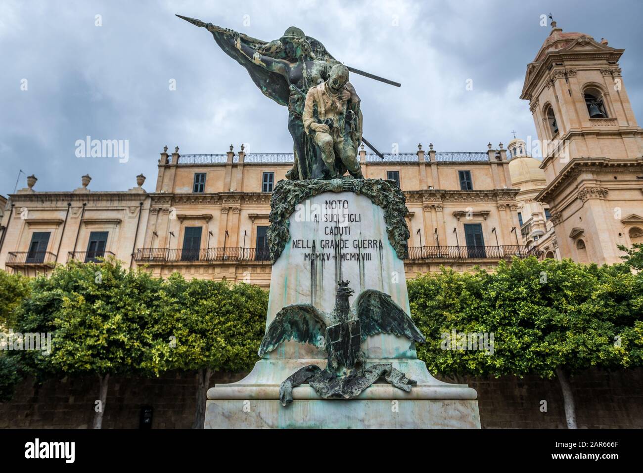 'Per figli di Noto ucciso nella Grande Guerra 1915-1918' statua che si trova nella città di Noto in Sicilia in Italia. Palazzo Landolina sullo sfondo Foto Stock