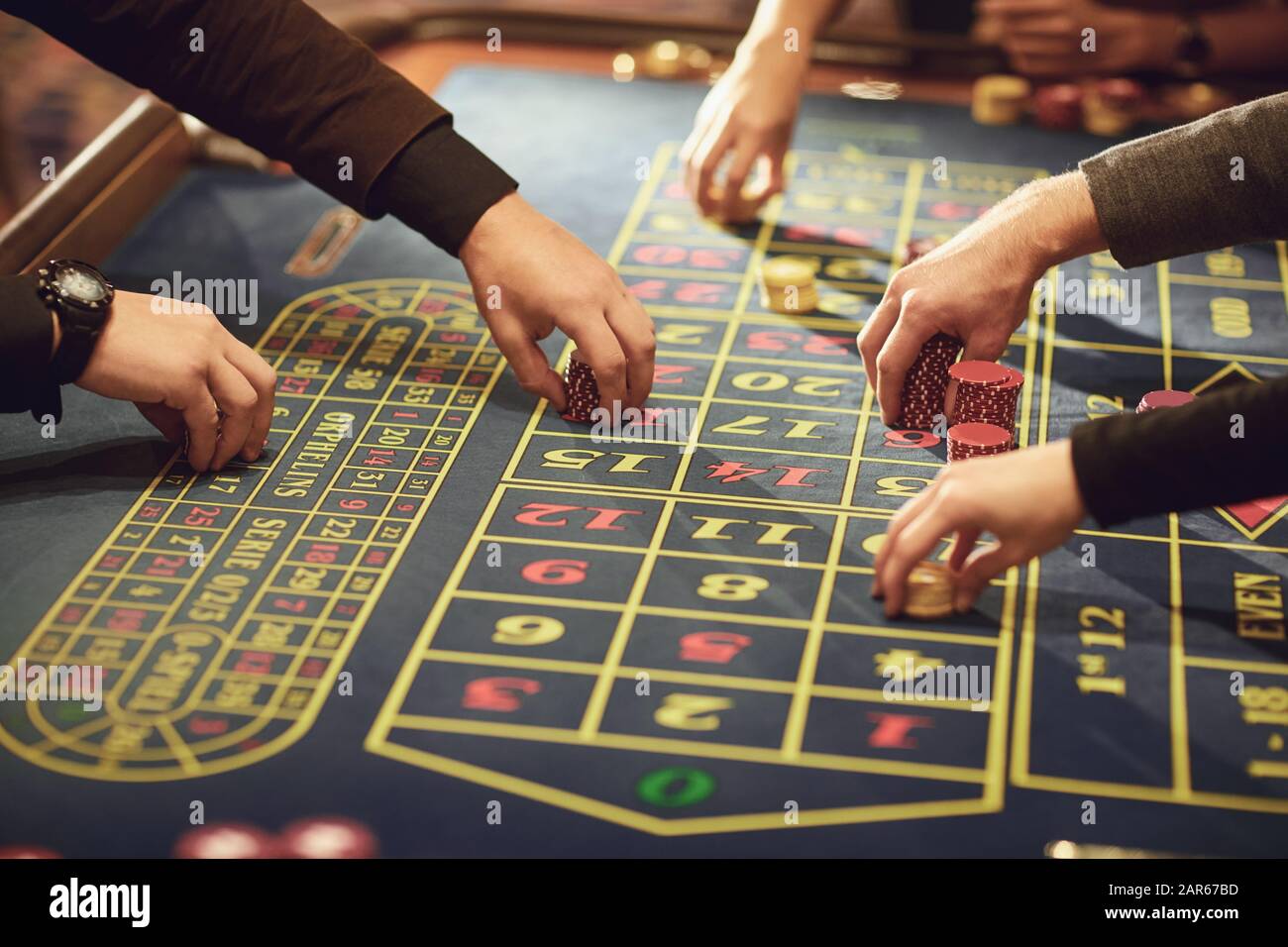 Una mano con i chips effettua una puntata alla roulette in un casinò. Foto Stock