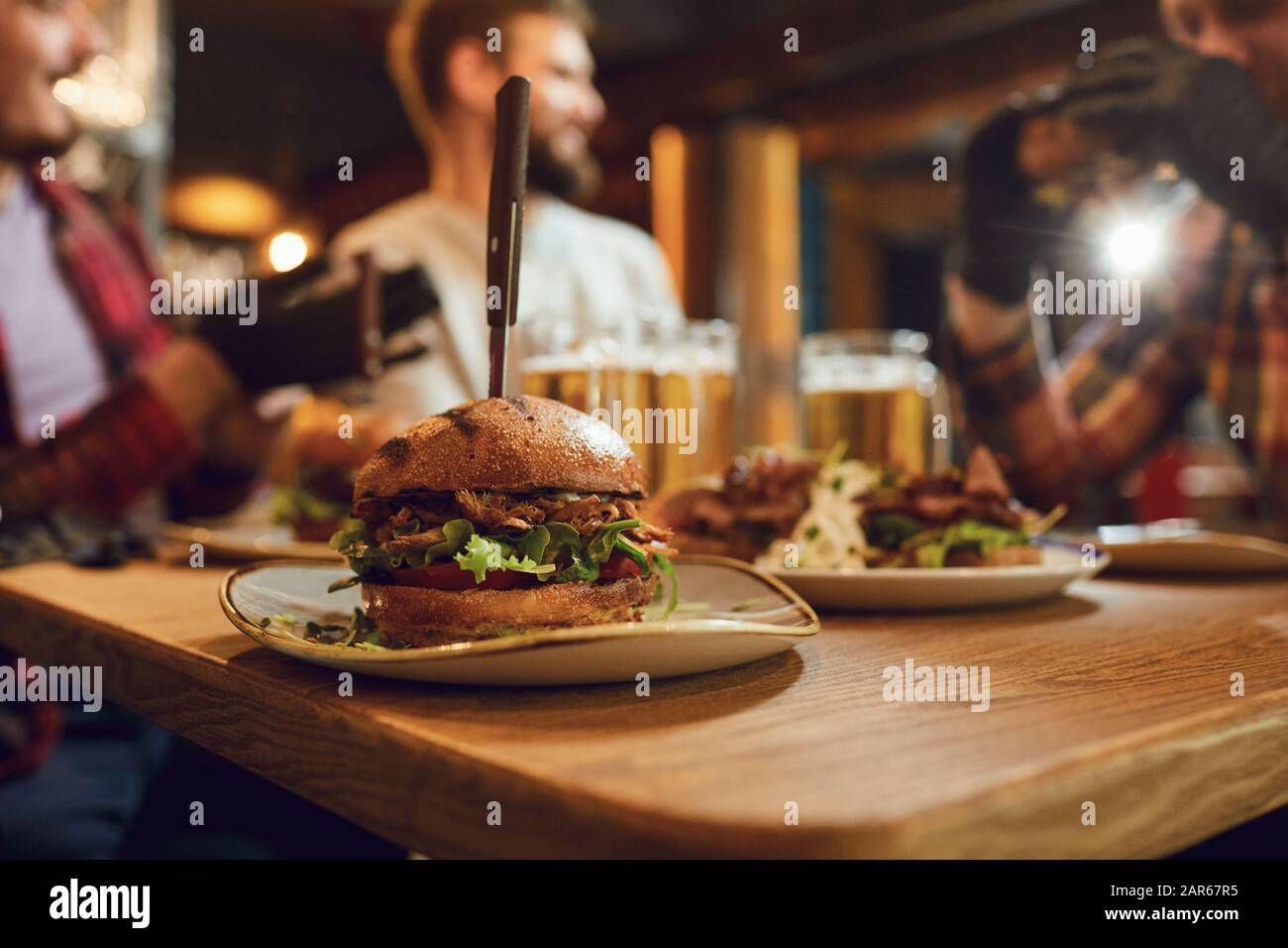 Burger con la birra sul tavolo in un bar pub. Foto Stock