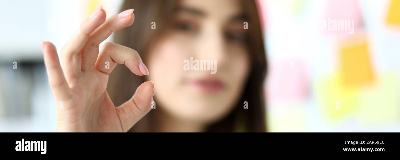 Addetto alla femmina che mostra tutto il simbolo a destra con le dita Foto Stock