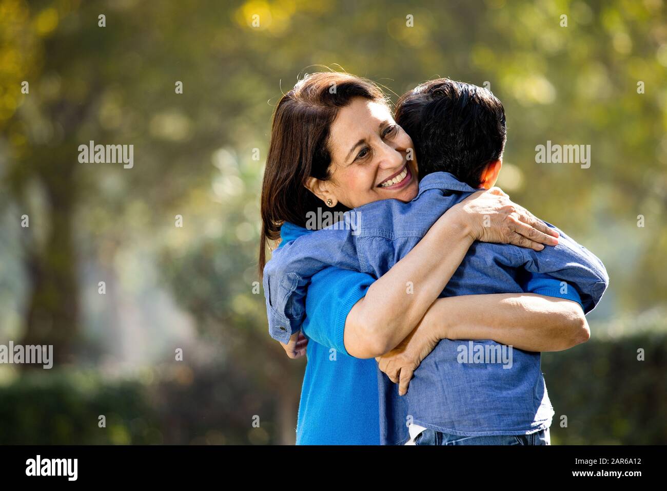 Donna che abbraccia il nipote al parco Foto Stock