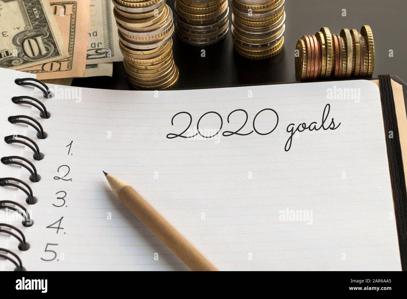 Una pagina con il testo degli obiettivi 2020, sfondo monetario. Argomento dei sogni, obiettivi, piani, promesse Foto Stock