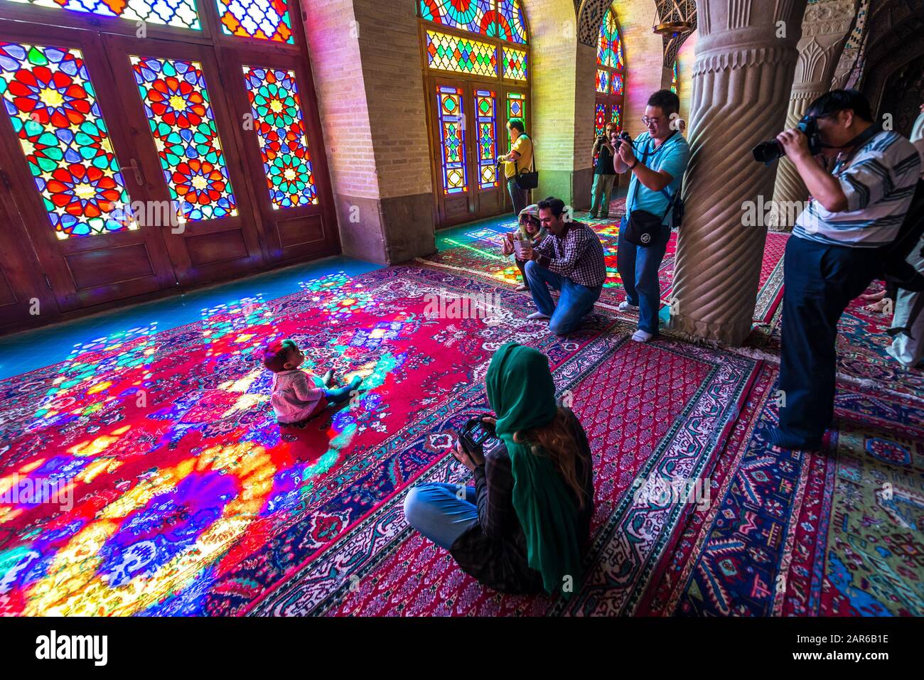 I turisti prende le foto del bambino iraniano nel cosiddetto rosa (la Moschea di Nasir ol Molk Moschea) in Gowad-e-Araban distretto della città di Shiraz in Iran Foto Stock