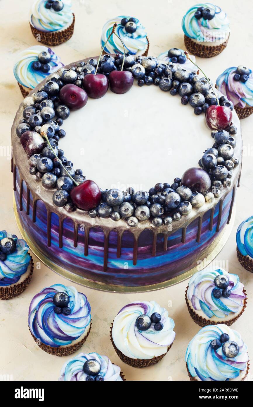 Torta blu festosa con frutti di bosco e cioccolato e cupcake con crema, caramelle bar, Sweet bar Foto Stock