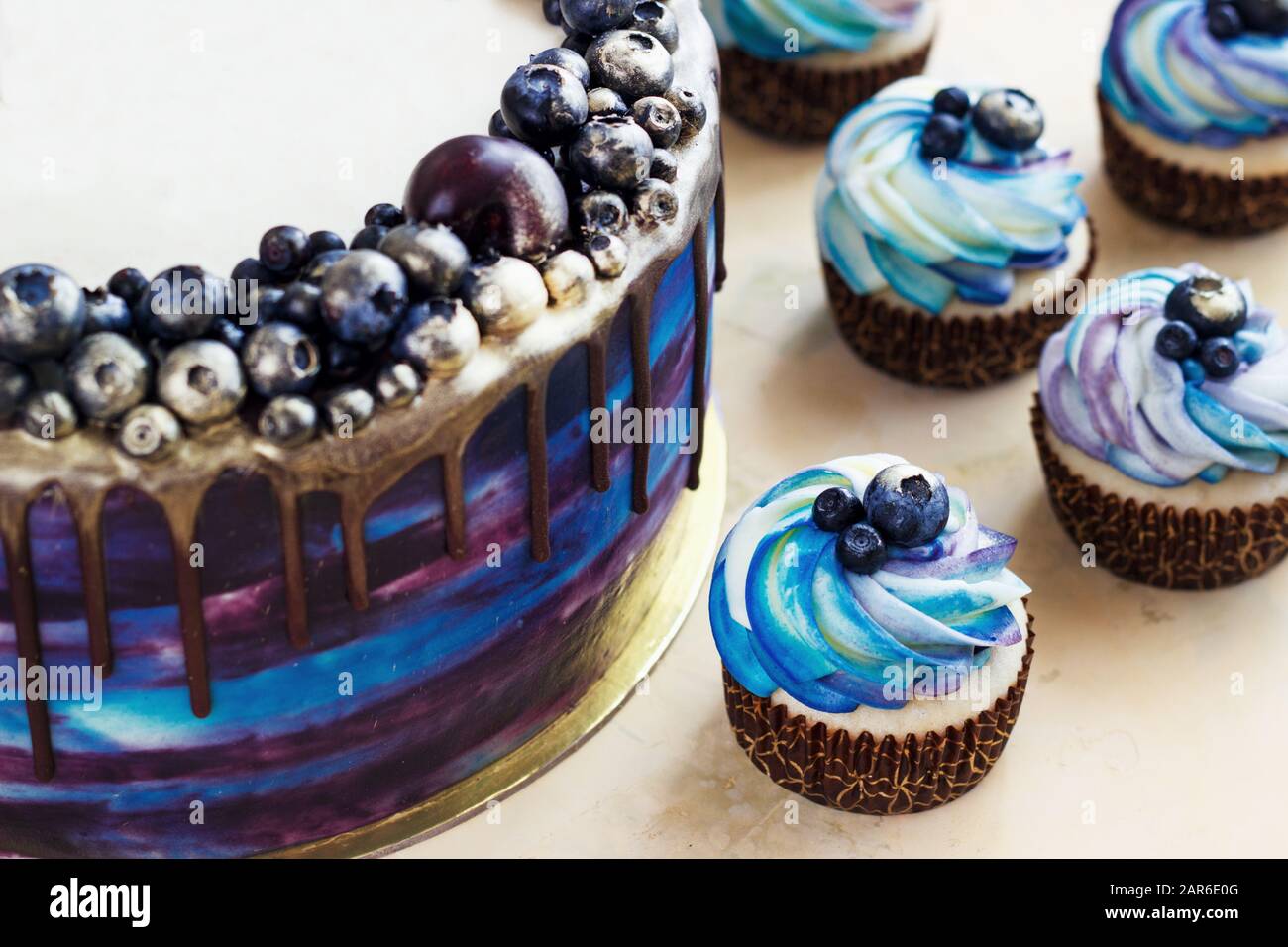 Torta blu festosa con frutti di bosco e cioccolato e cupcake con crema, caramelle bar, Sweet bar Foto Stock