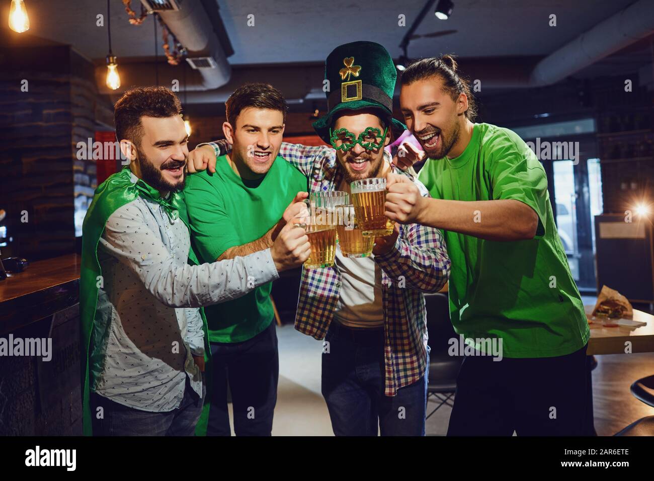Amici felici che celebrano il giorno di San Patrizio in un bar. Foto Stock