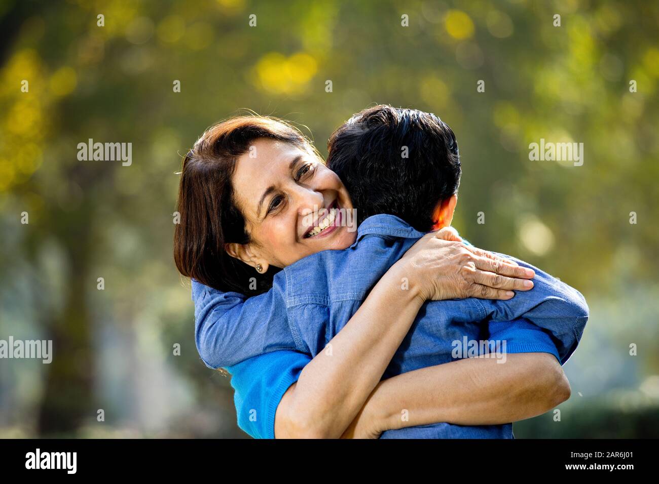 Donna che abbraccia il nipote al parco Foto Stock
