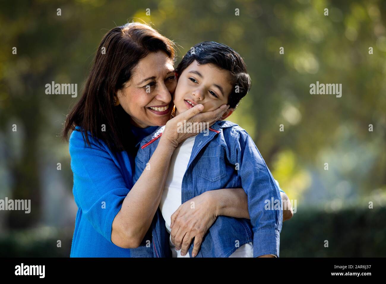 Donna che abbraccia il nipote al parco Foto Stock