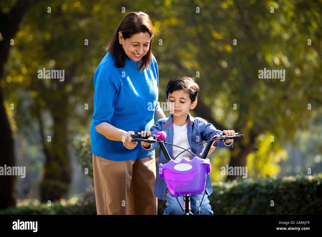 Nonna con nipote imparare a guidare la bicicletta Foto Stock