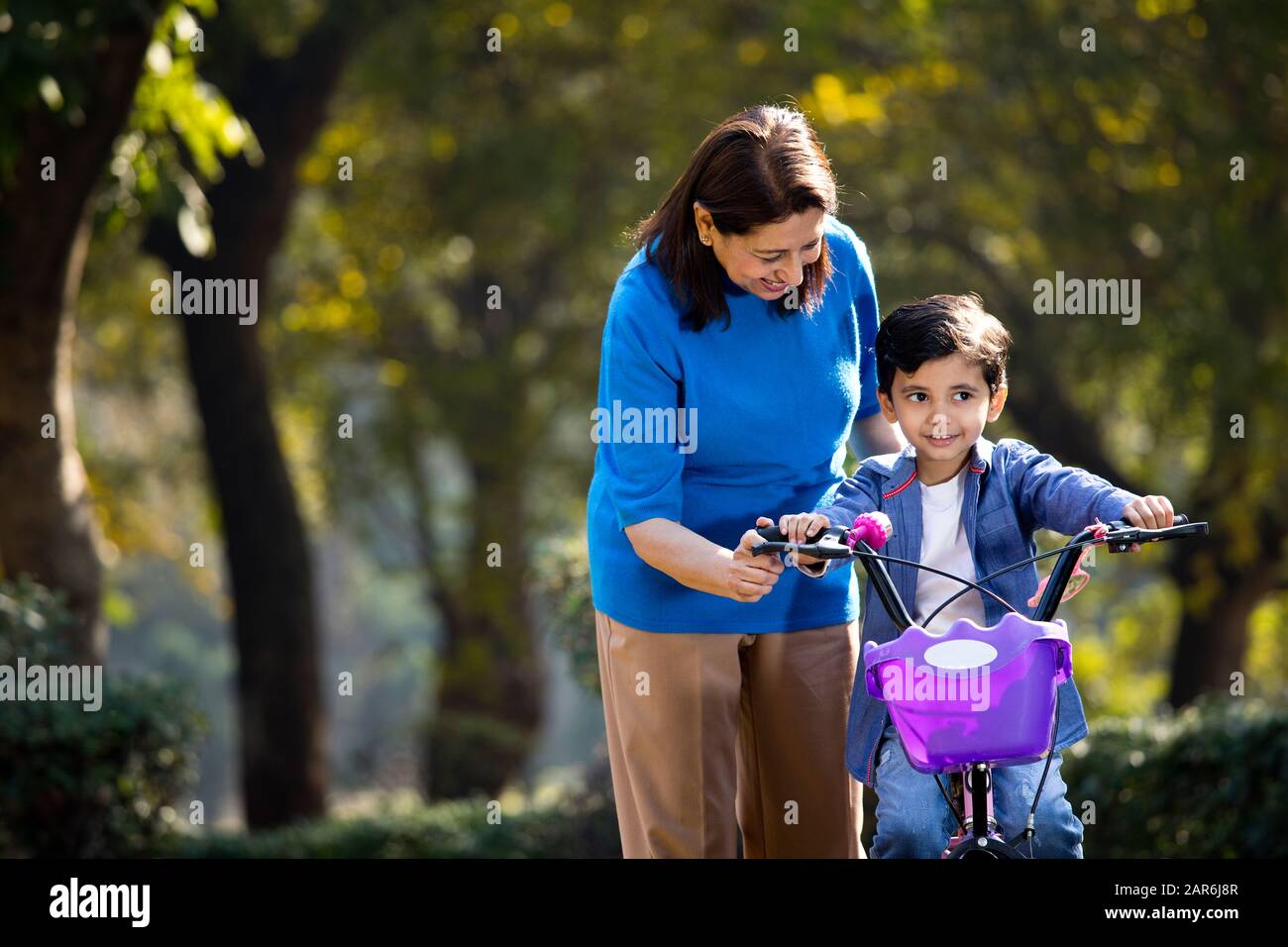 Nonna con nipote imparare a guidare la bicicletta Foto Stock