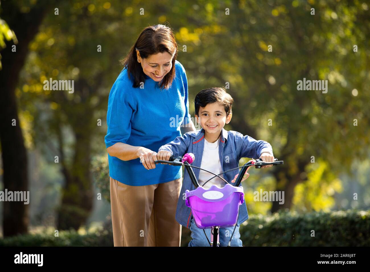 Nonna con nipote imparare a guidare la bicicletta Foto Stock