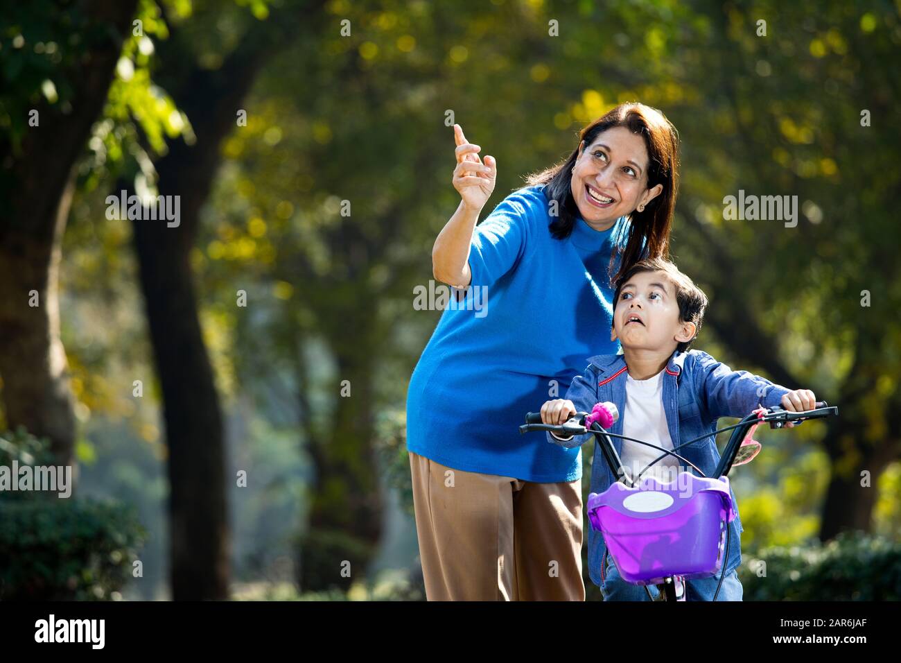 Nonna con nipote imparare a guidare la bicicletta Foto Stock