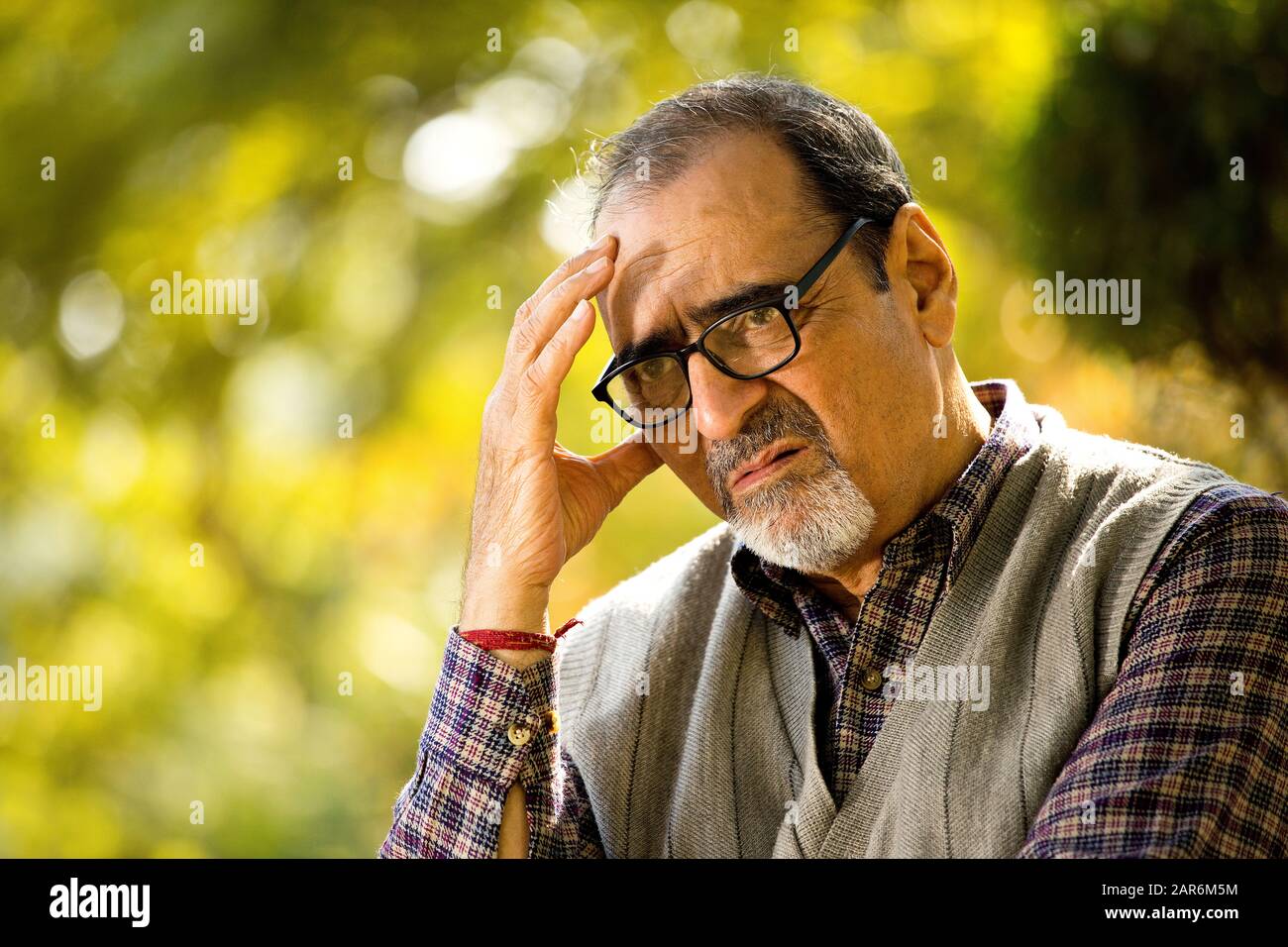 Uomo vecchio pensieroso al parco Foto Stock