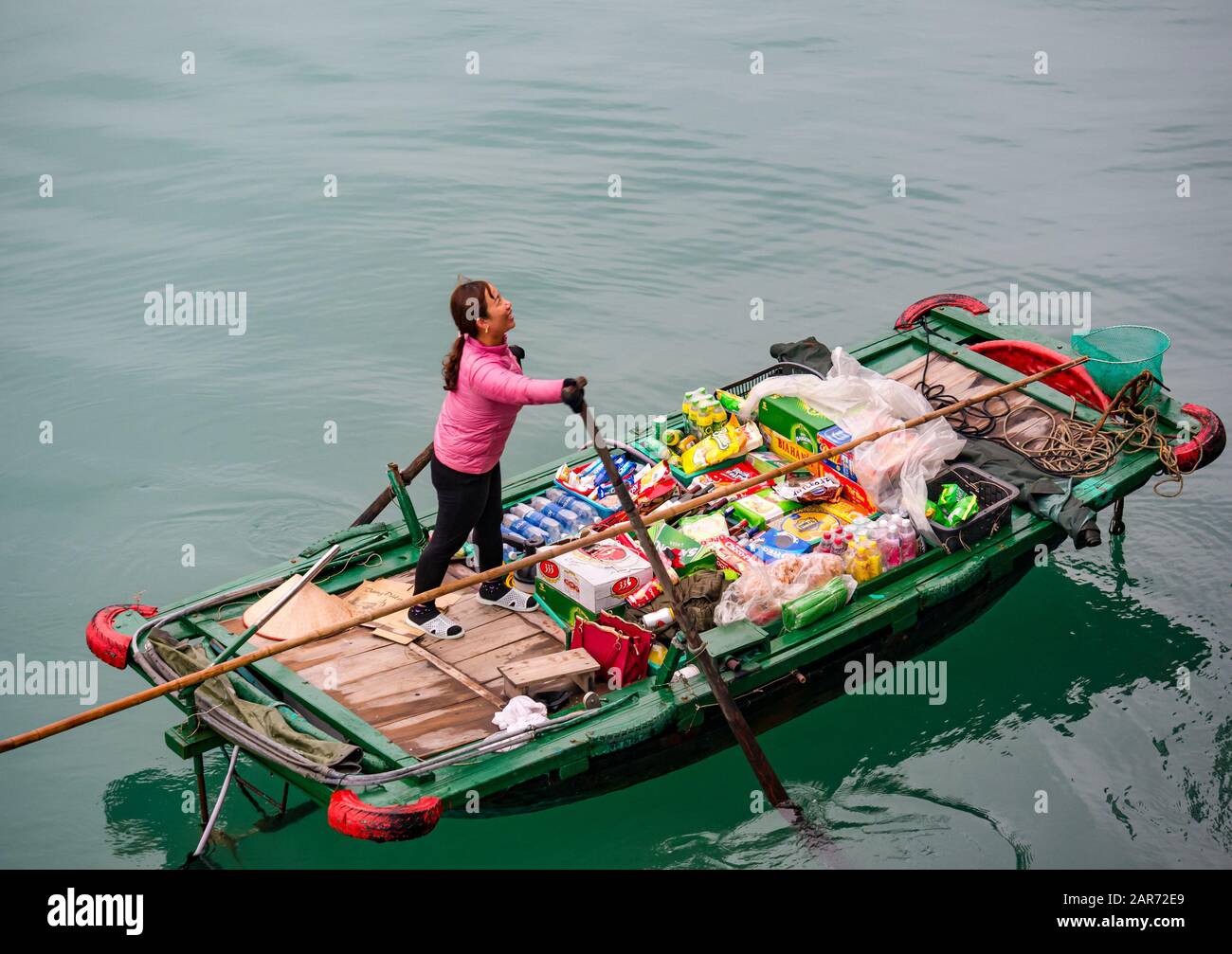 Asian vietnamita donna che vende beni da piccola barca per i turisti, Halong Bay, Vietnam, Asia Foto Stock