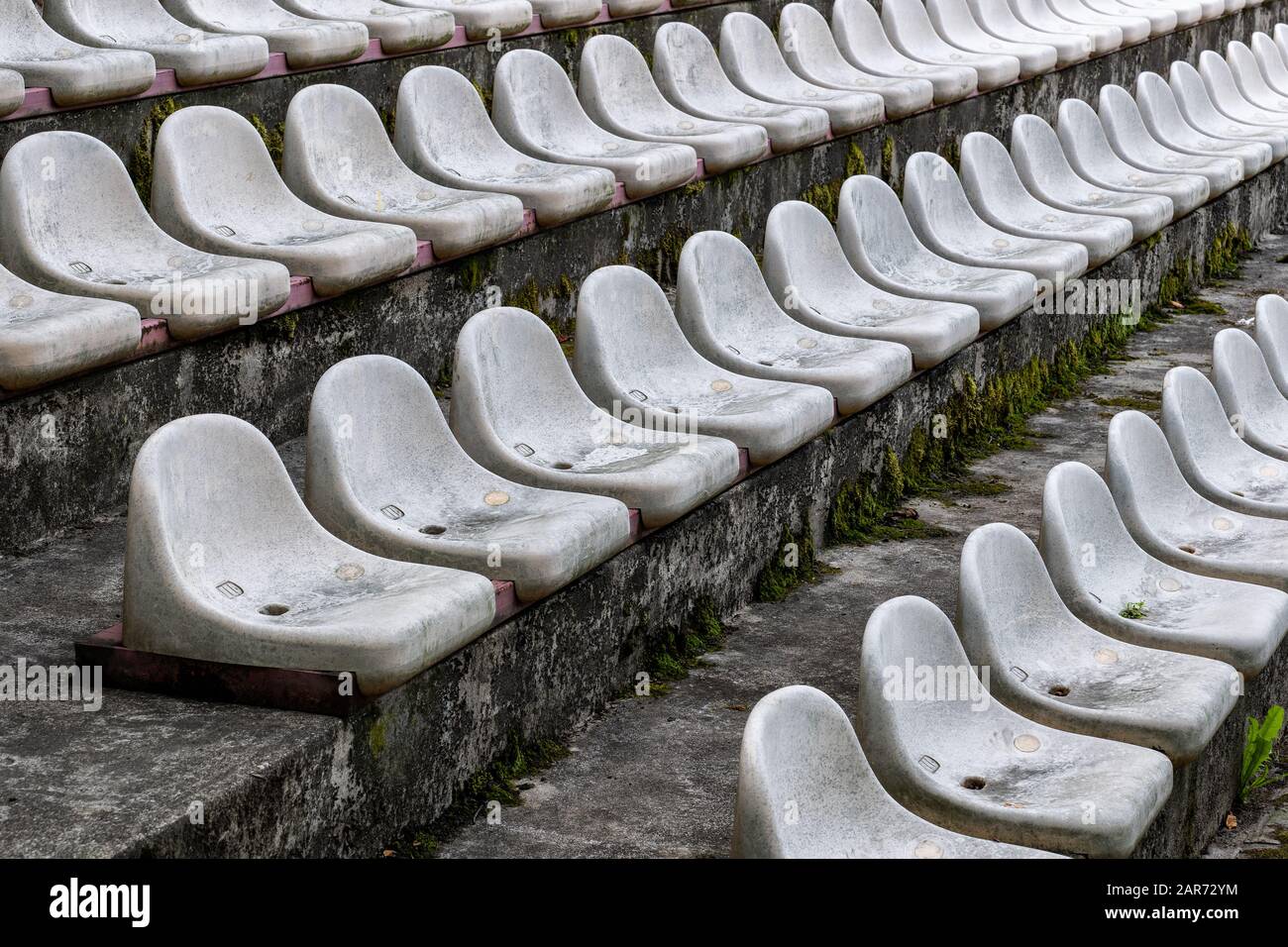 Lo stadio ospita uno sfondo astratto, linee di vecchie e sporche sedie bianche in tribune arena sportiva Foto Stock