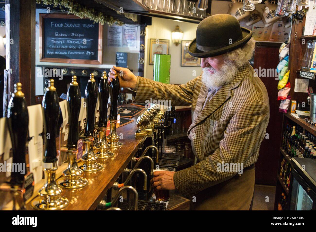 Drayman, Roger Hughes versa una pinta di birra per dare ai cavalli di razza Shire come ricompensa per il loro duro lavoro in uno dei pub del villaggio, un breve distanc Foto Stock