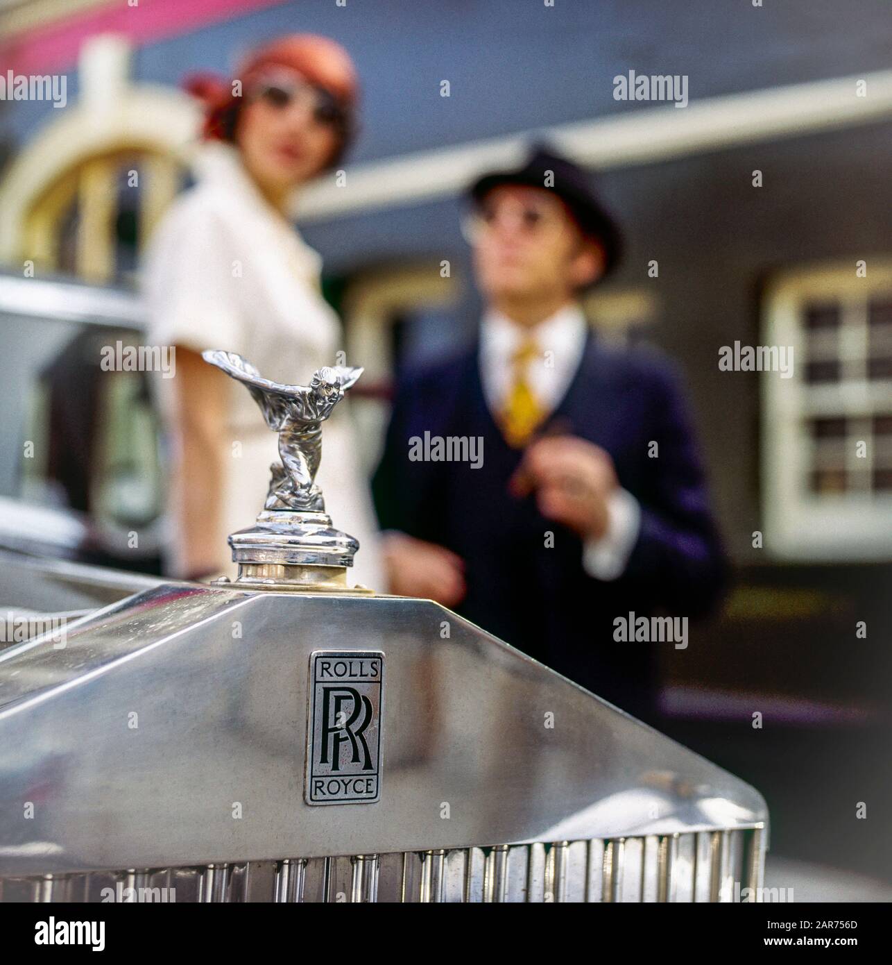 Londra 1970s, 1936 griglia radiatore Rolls-Royce, statua Spirit of Ecstasy, ornamento cofano, mascotte, coppia elegante sfocata, Inghilterra, Regno Unito, GB, Gran Bretagna, Foto Stock