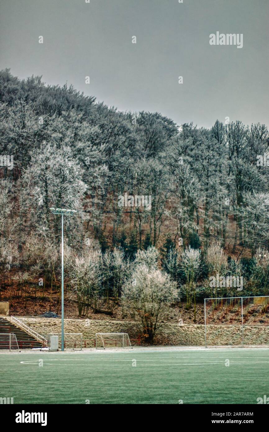 campo da calcio invernale con montagne ghiacciate in background e gol Foto Stock