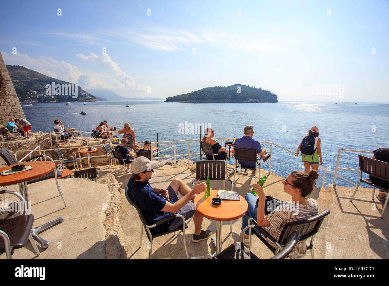 I turisti possono gustare un drink sulla terrazza del Buza Bar sulle mura della città, vicino al mare Adriatico. Dubrovnik Foto Stock