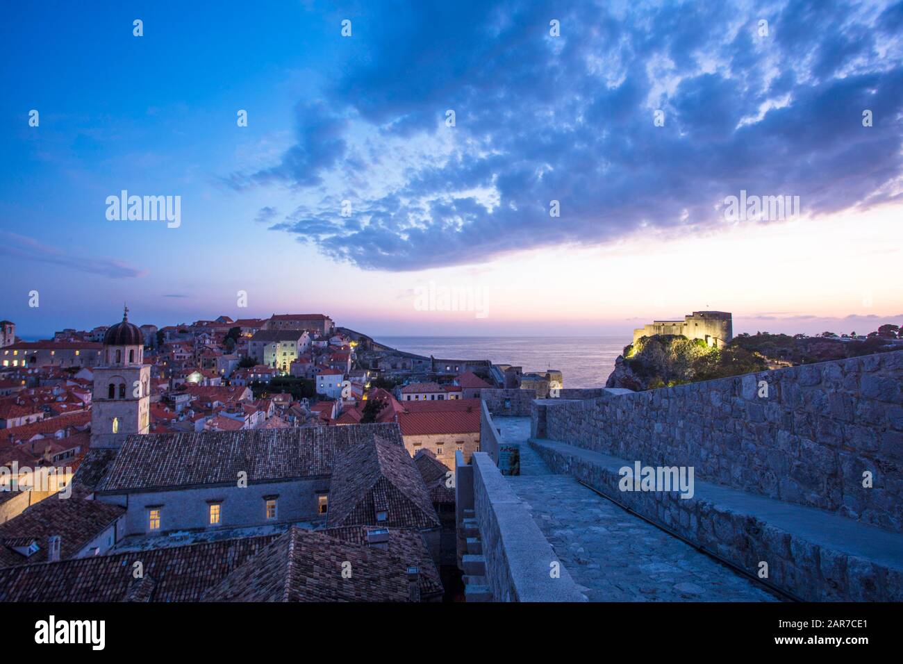 Il tramonto della città vecchia di Dubrovnik dalla cima delle mura della città. A sinistra si trova il Monastero Francescano e a destra il Forte Lovrijenac. Foto Stock