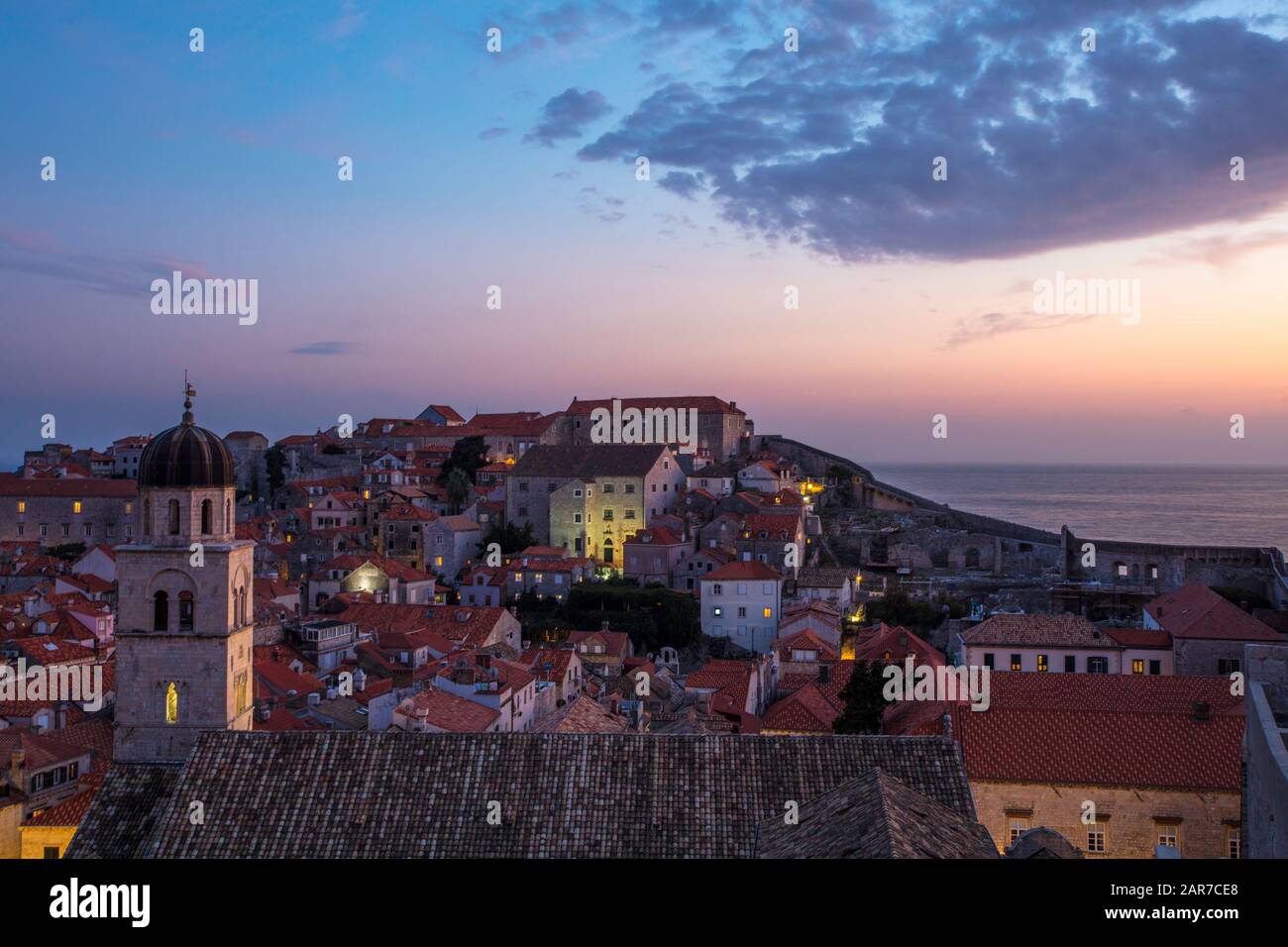 Tramonto sulla città vecchia di Dubrovnik, vista dalla cima delle mura della città, con la torre del monastero francescano in primo piano. Croazia Foto Stock