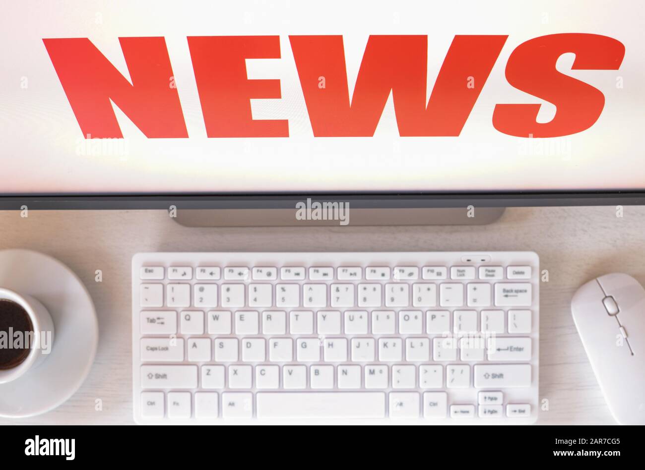 Monitor del computer con testo "News" visualizzato tastiera, mouse, caffè. Concept, notizie sensazionali, eventi, last minute Foto Stock