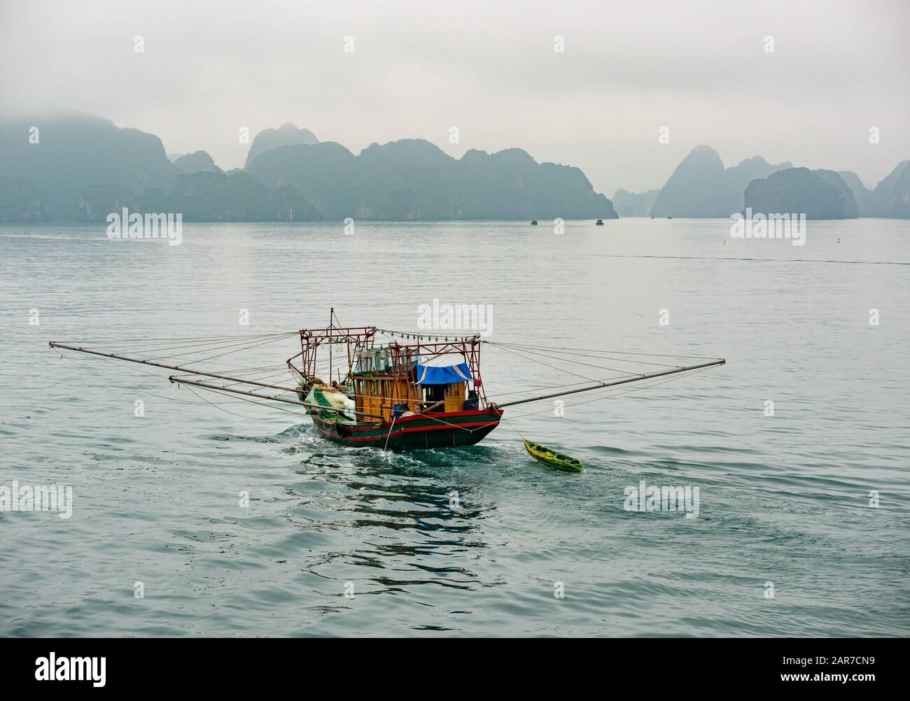 Tradizionale barca da pesca vietnamita con formazioni rocciose carsiche calcaree, Halong Bay, Vietnam, Asia Foto Stock