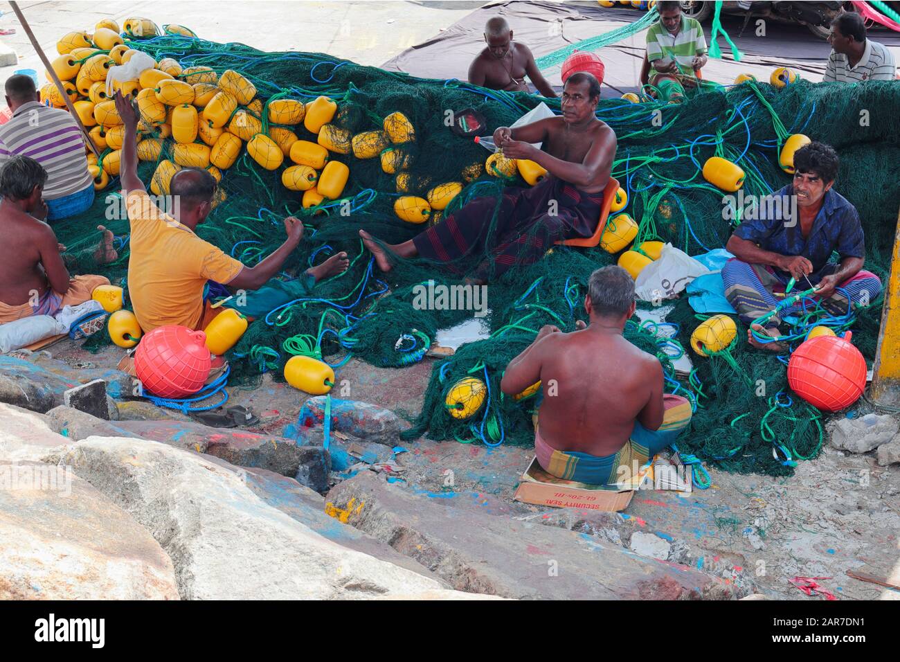 Pescatori che mending le loro reti nel porto di Mirissa Foto Stock