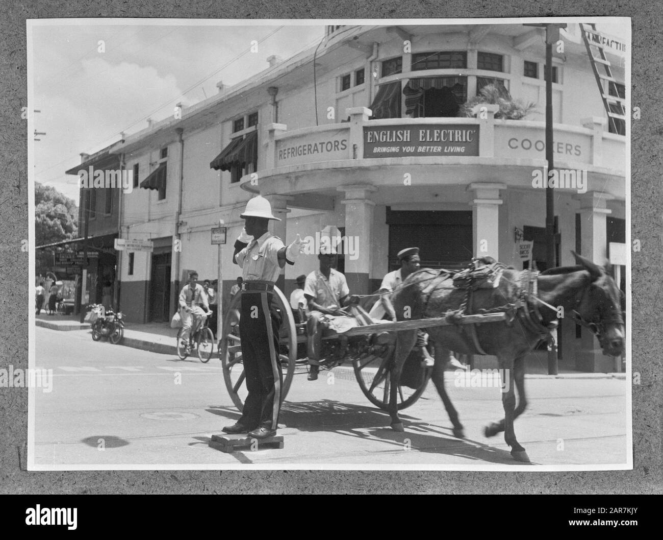 Ufficiale di polizia e cavallo e carrello a Kingston in Giamaica. In background in negozio di elettrodomestici Data: 1 ottobre 1955 posizione: Giamaica, Kingston Parole Chiave: Cavalli, polizia, immagini della città, trasporti, negozi Foto Stock
